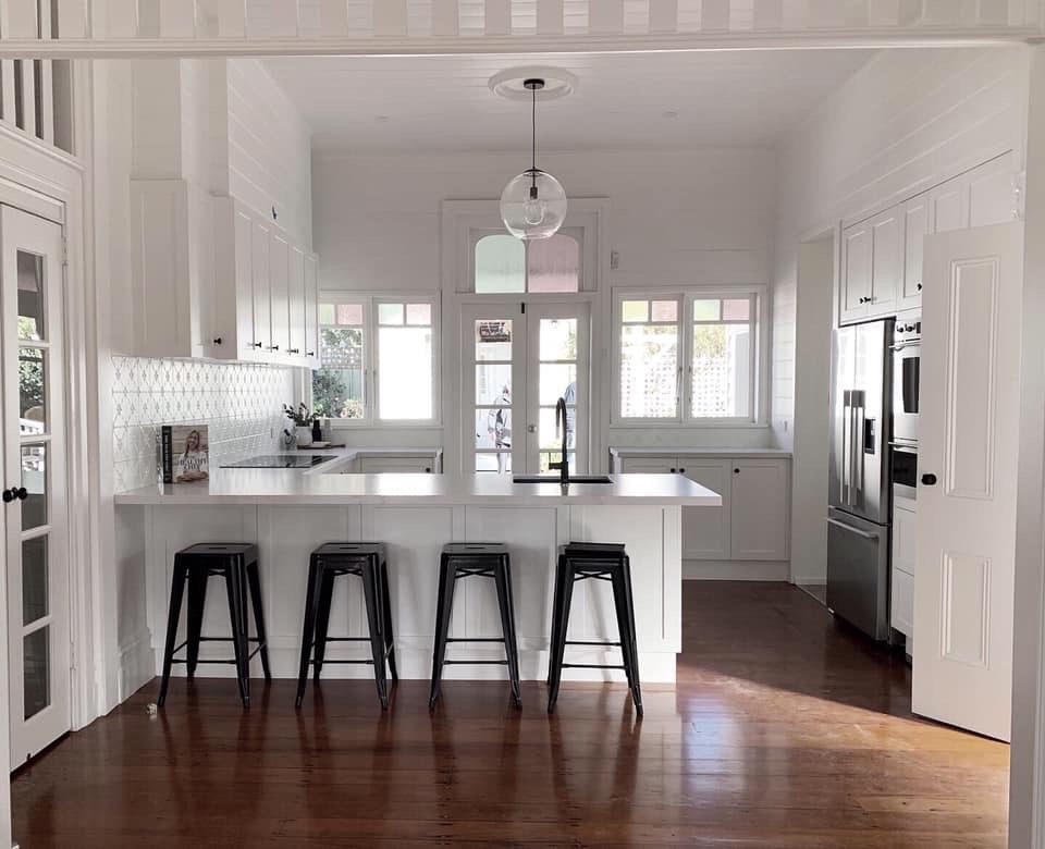 All white shaker cabinetry in a period cottage with a breakfast bar