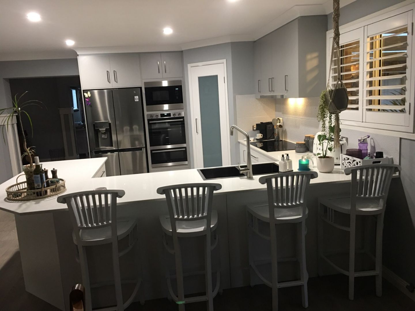 Soft grey kitchen with a peninsula bench and a wall oven tower