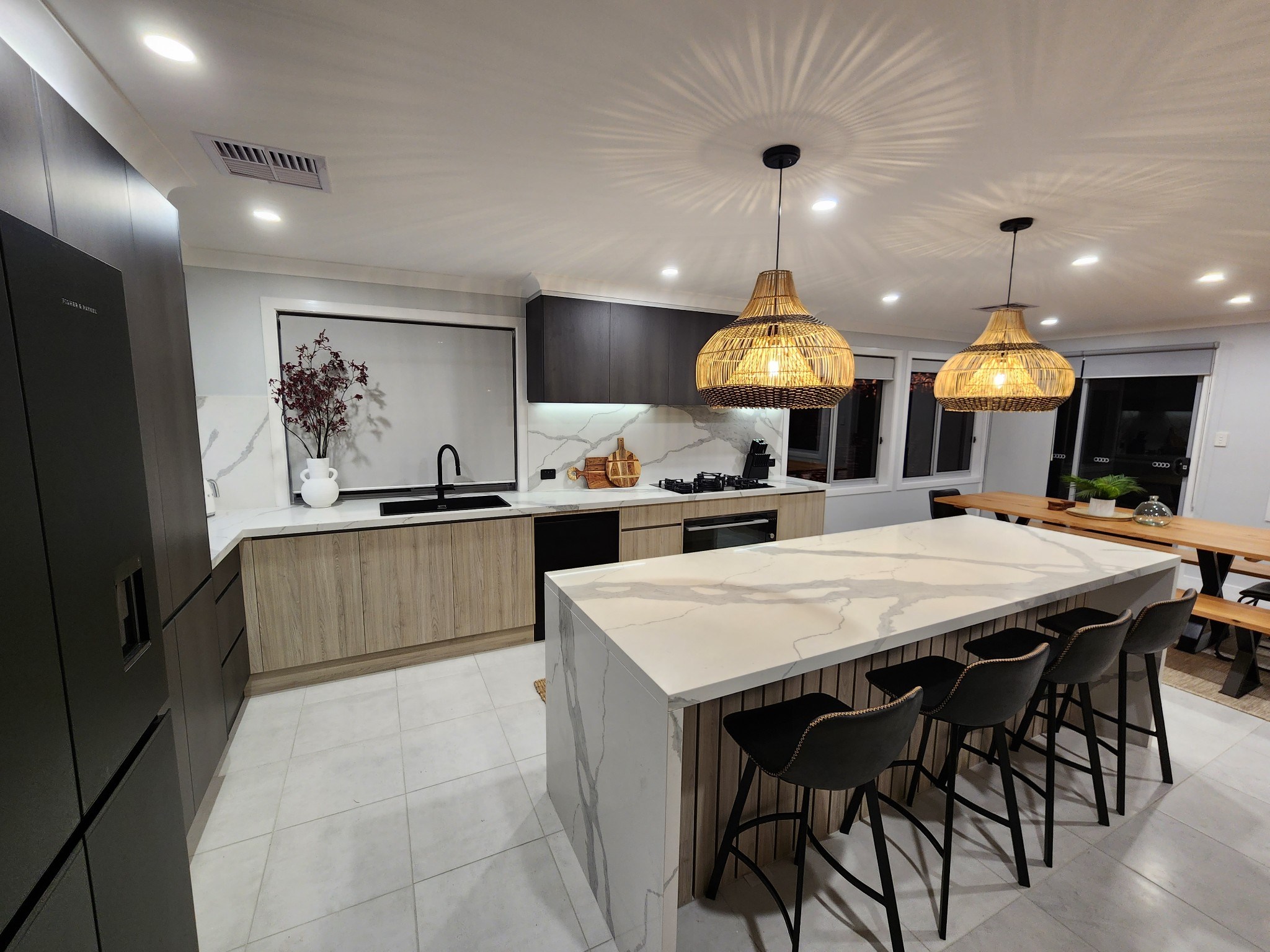 A charcoal and oak kitchen with a stone waterfall island, built by Superior Cabinets South Coast